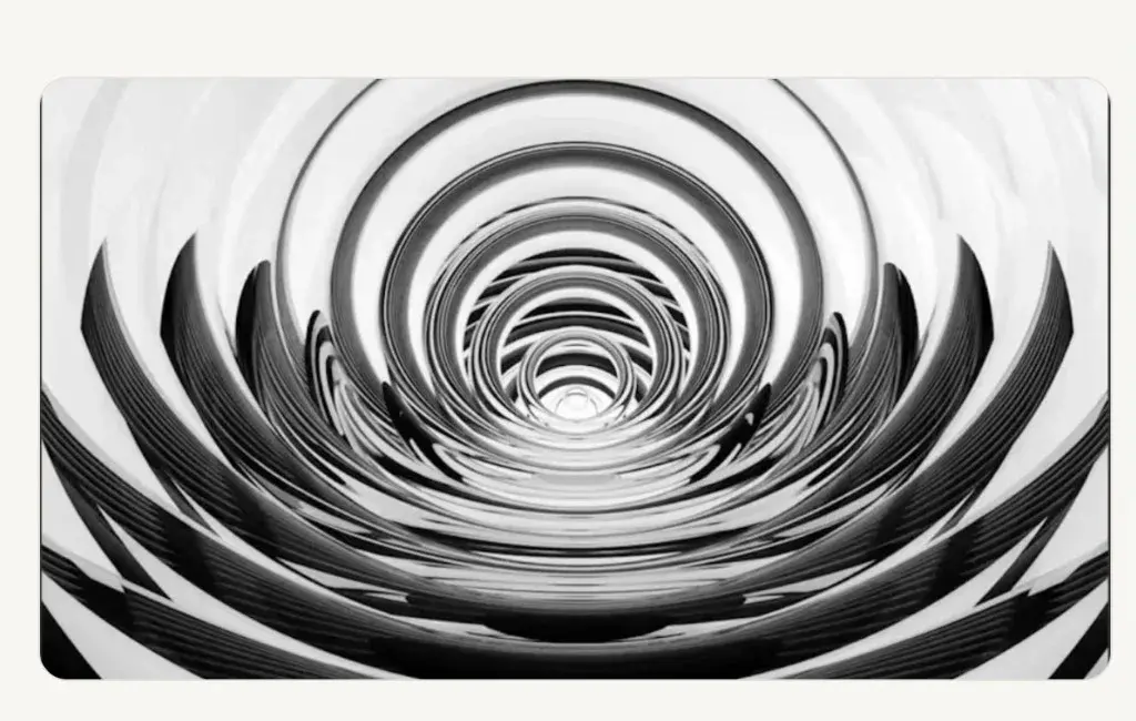 Abstract black-and-white tunnel of concentric rings drawing inward toward a bright center